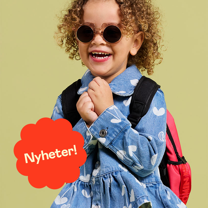 Två barn klädda i färgglada kläder går nedför en trätrappa utomhus.