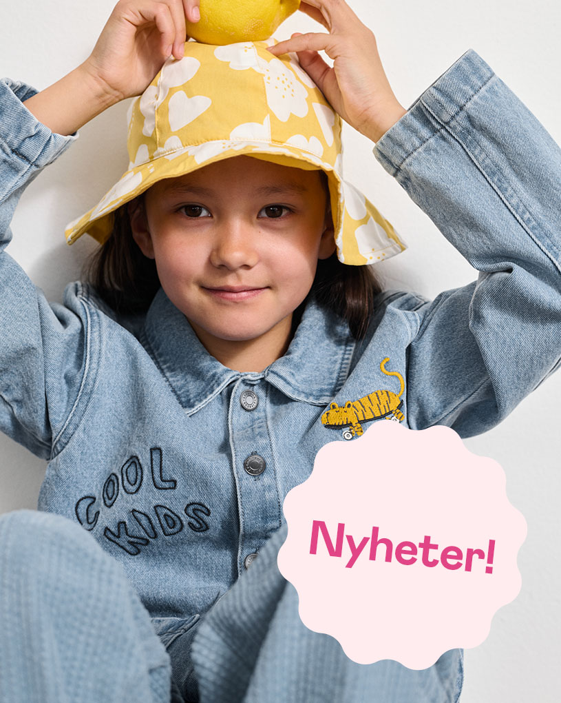 Barn på höbal i prickig tröja med text: Nyheter!