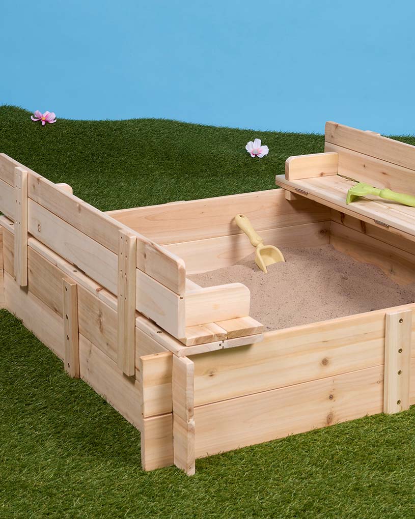 Barn leker i trälåda formad som båt med ratt.