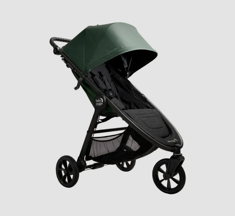 Svart och grön barnvagn med tre hjul på grå bakgrund.