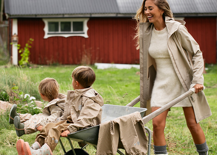 En kvinna skjuter en skottkärra med två barn, med texten 'Kenza X Viking'.