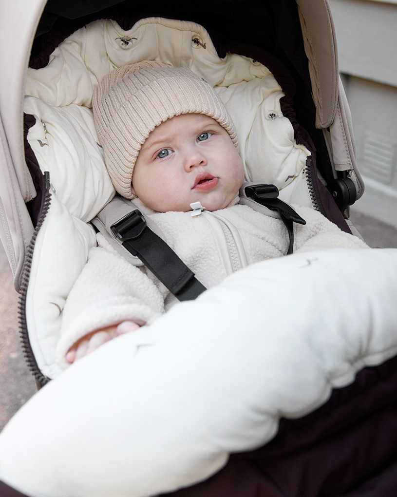Hand i barnvagnshandvärmare utomhus.