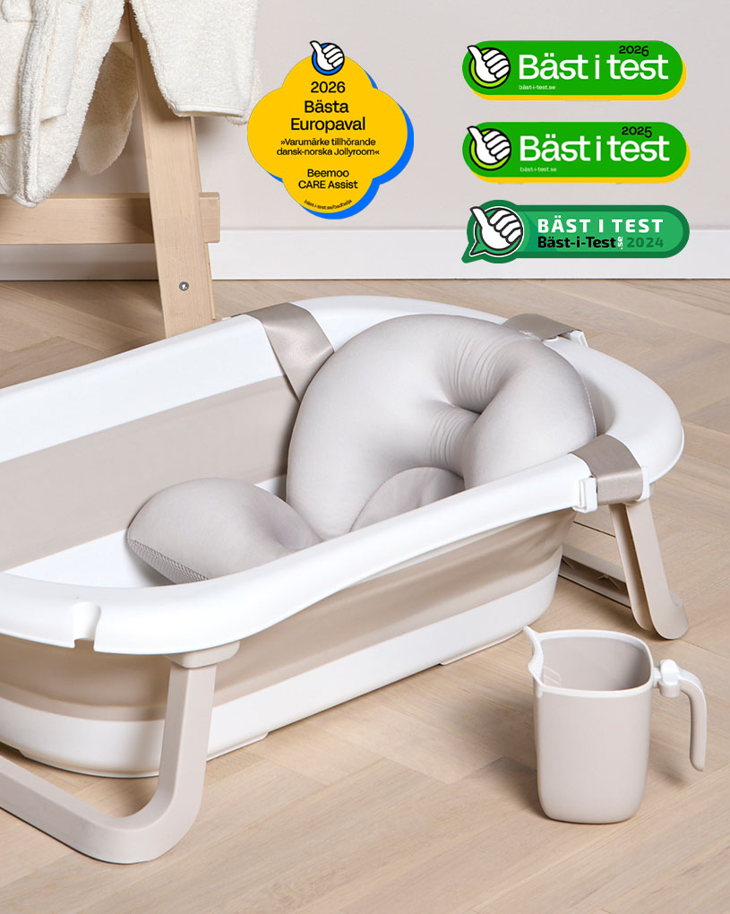 Hopvikbart babybadkar bredvid handduk och anka på bänk.