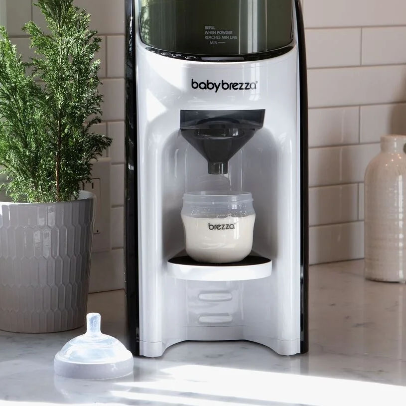 Person tillreder nappflaska med hjälp av babyproduktmaskin.