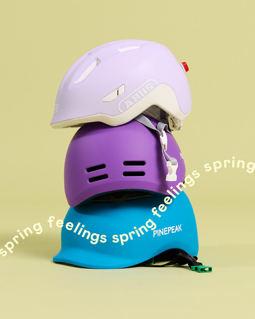 Tre cykelhjälmar i olika färger med texten 'spring feelings'.