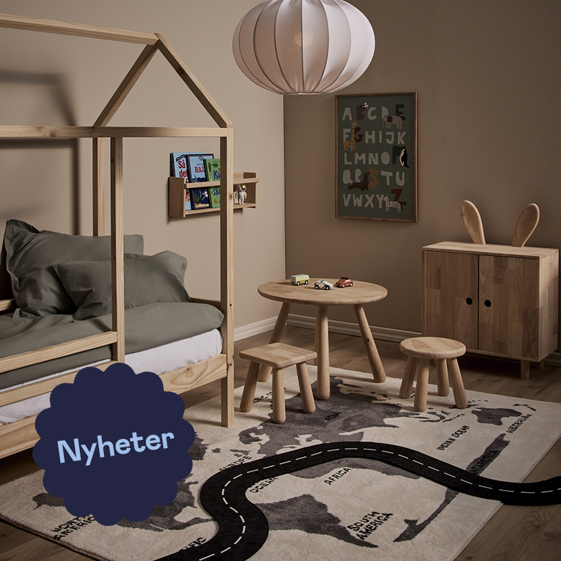 Barnrum med säng, bord och stolar i trä, världsmatta och hylla.