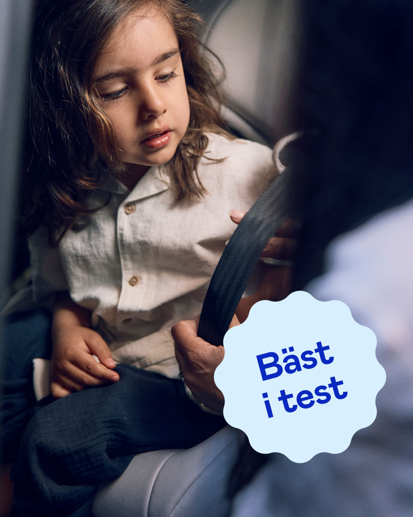 Leende barn i bilbarnstol med "Bäst i test"-märkning.