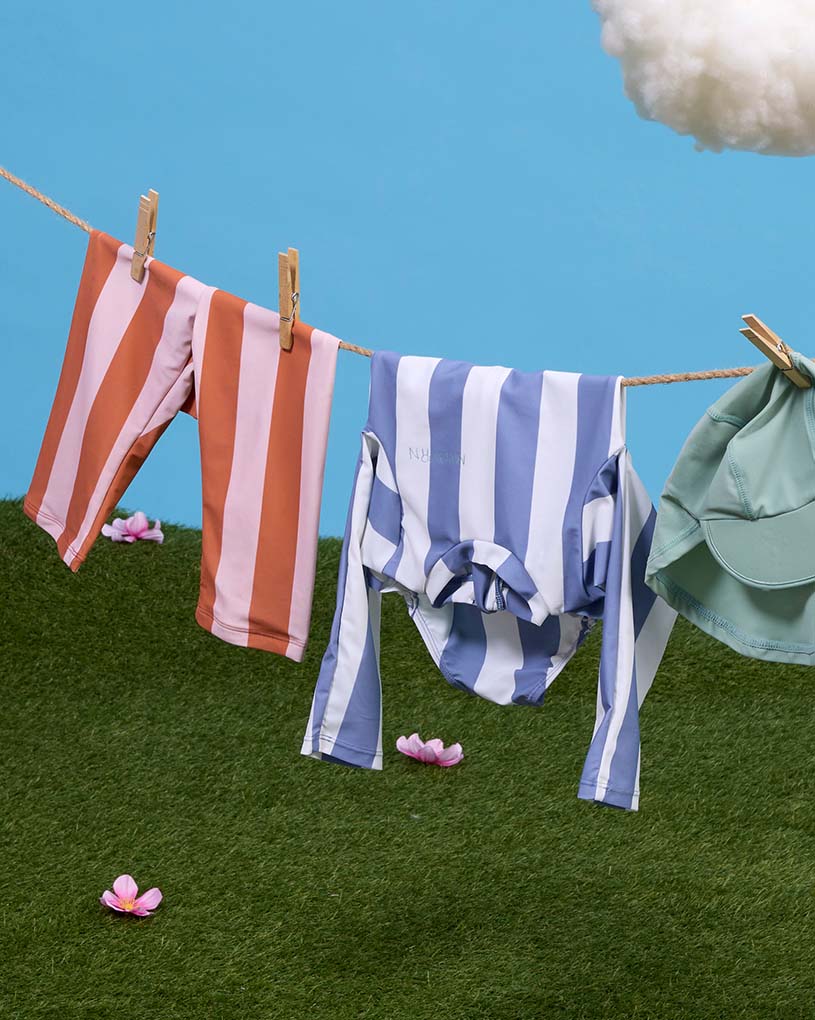 Barn i leopardmönstrad dräkt leker i uppblåsbar pool.