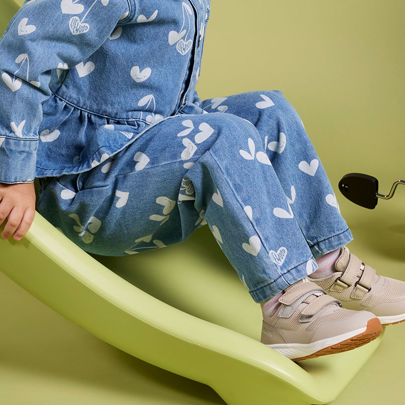 Barn i lila shorts och vita sneakers.