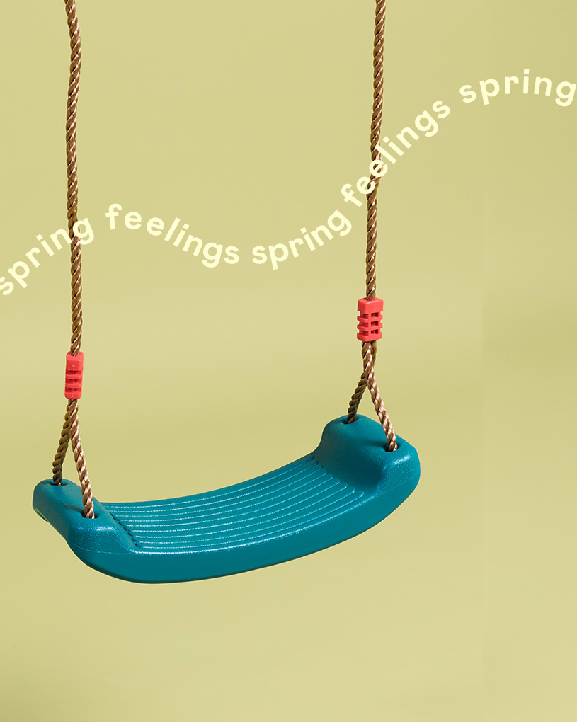 En blå gunga med texten 'spring feelings spring feelings'.