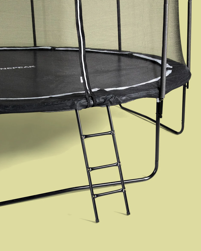 En svart studsmatta med en stege, på en ljus bakgrund.