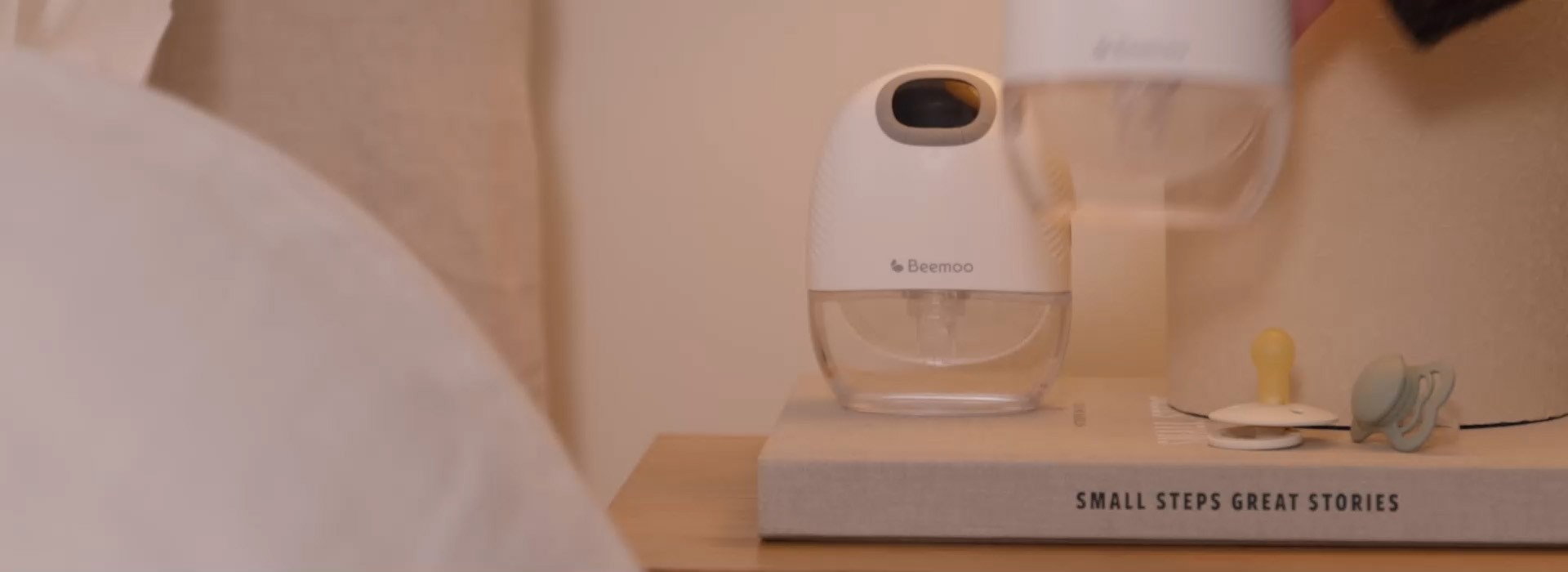 Kvinna ler mot barn i barnvagn inomhus.