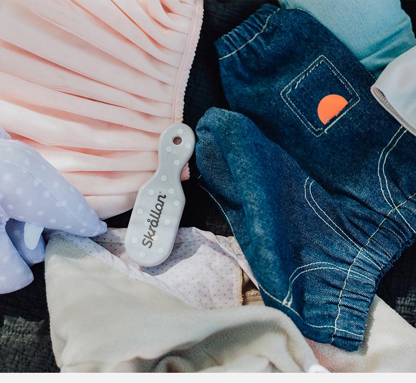 En närbild av babykläder och accessoarer på en filt.